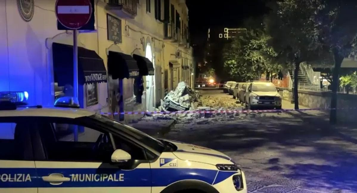 Carro esmagado por escombros de edifícios.